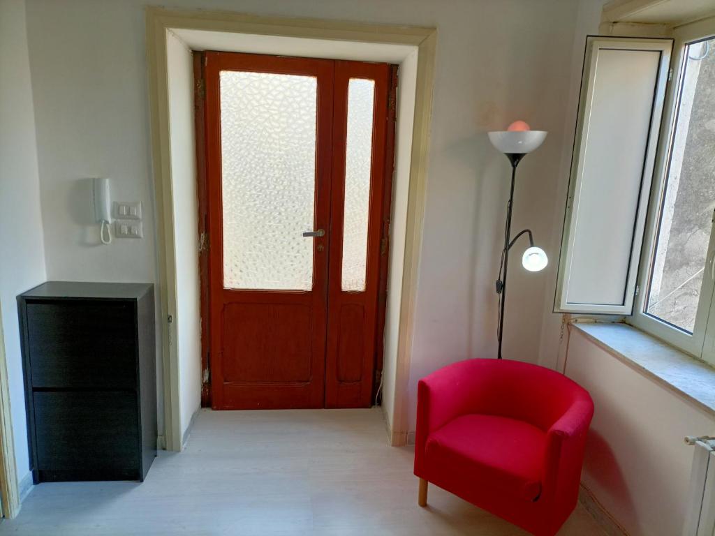 a red door in a room with a red chair at Il Borgo in Corbara