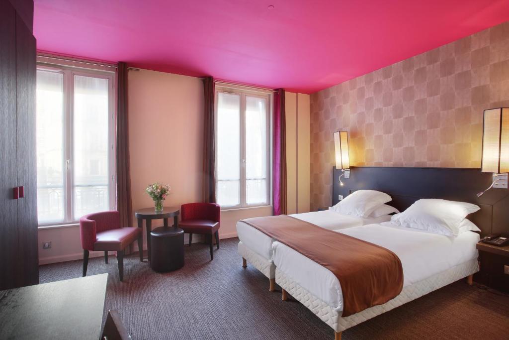 a bedroom with a large bed with a pink ceiling at Aéro in Paris