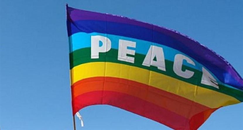 una bandiera di colore arcobaleno con la parola pace sopra. di Hotel Triana e Tyche a Sasso Marconi