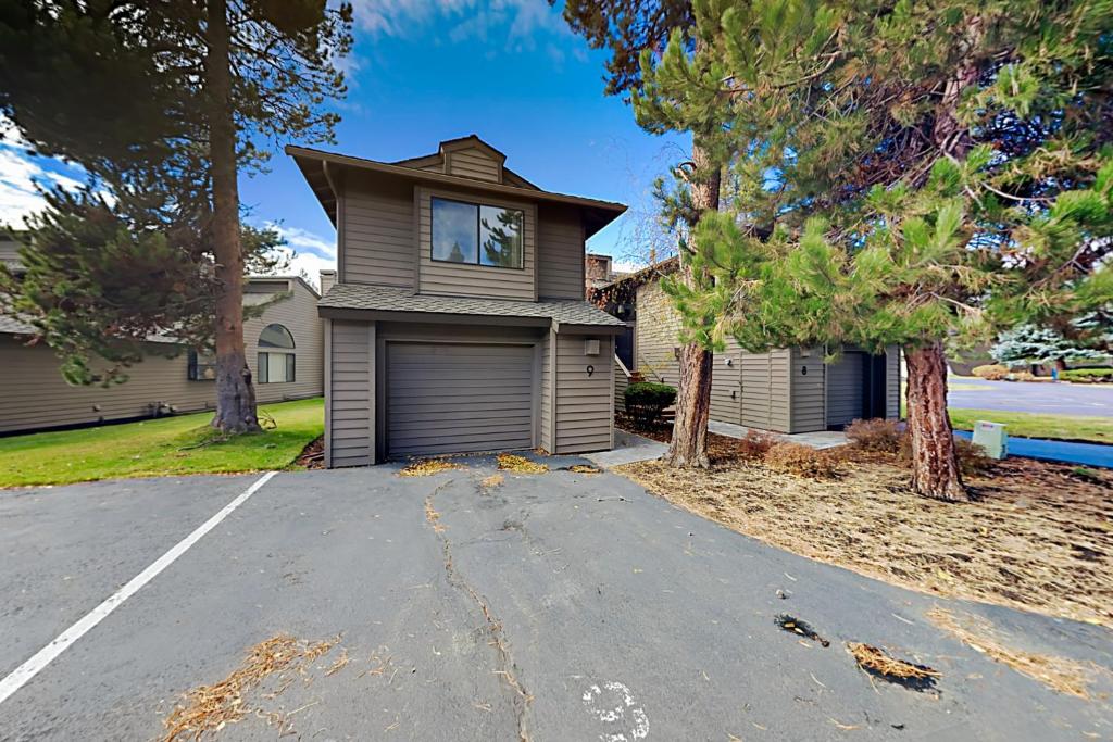 サンリヴァーにあるFairway Village Unit 9の家の前の私道付きの家