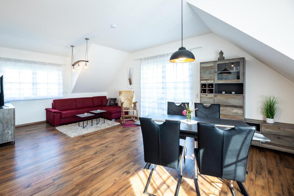 ein Wohnzimmer mit einem Tisch und einem roten Sofa in der Unterkunft Ferienwohnung Weingut Birnstingl in Gamlitz