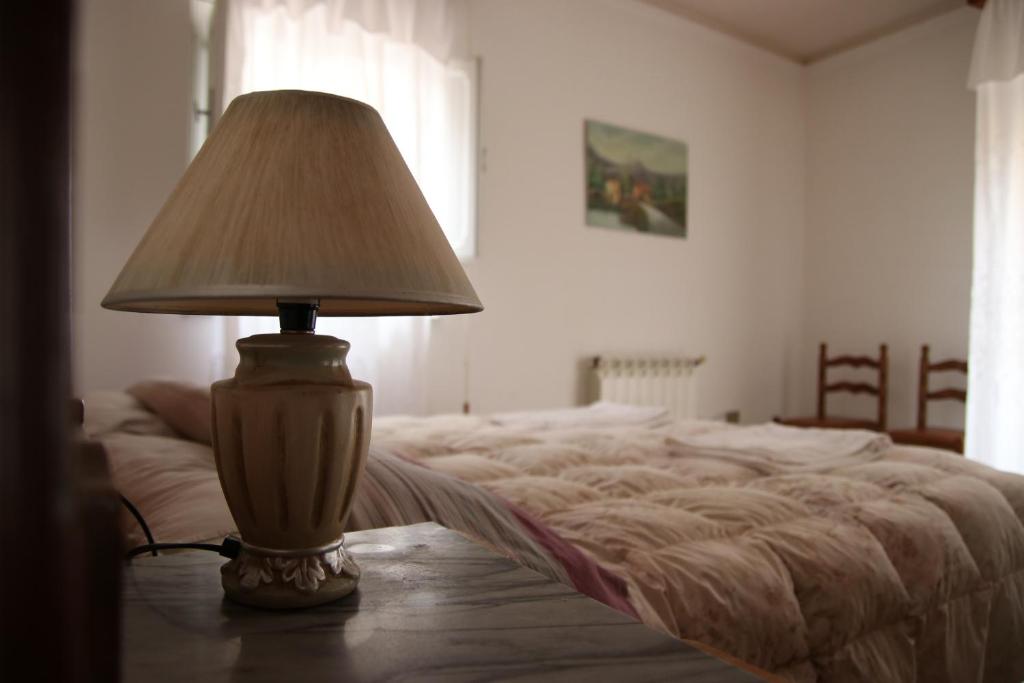 une lampe assise sur une table à côté d'un lit dans l'établissement Casa Salvaggio, à Grotte