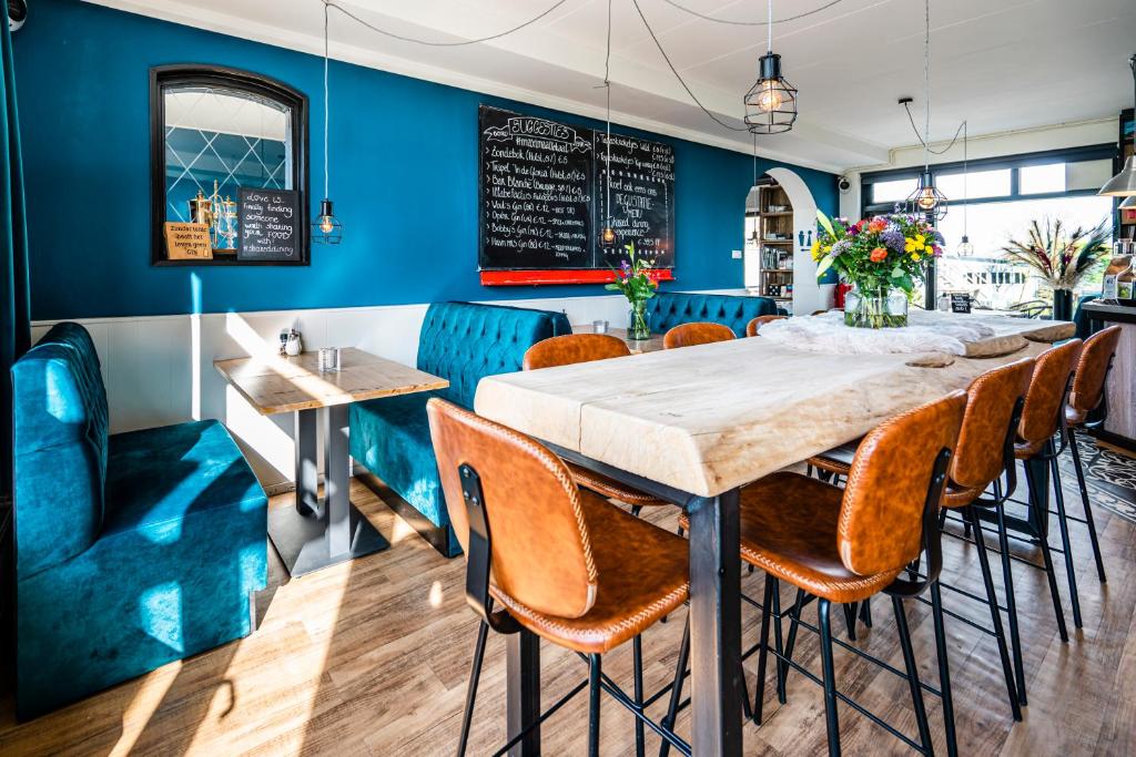 een eetkamer met blauwe muren en een tafel en stoelen bij Bruist in Cadzand