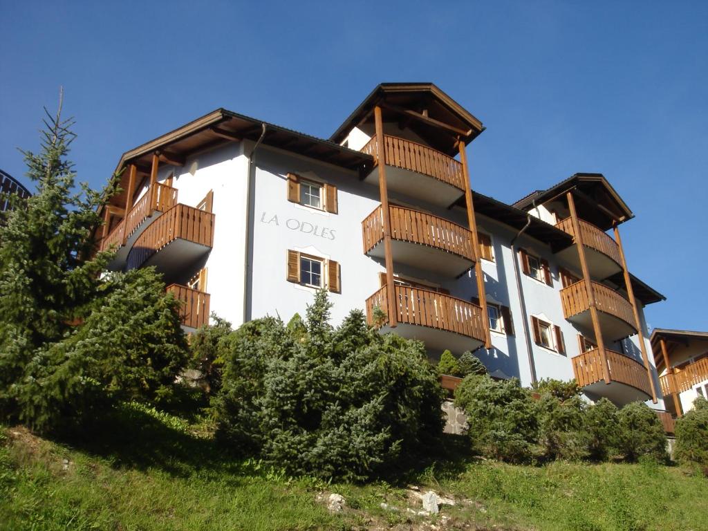 een groot wit gebouw met houten balkons bij La Odles in Selva di Val Gardena