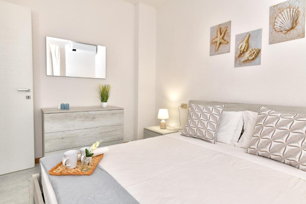 a white bedroom with a large bed with a tray on it at Residence Chiaro di Luna in San Teodoro