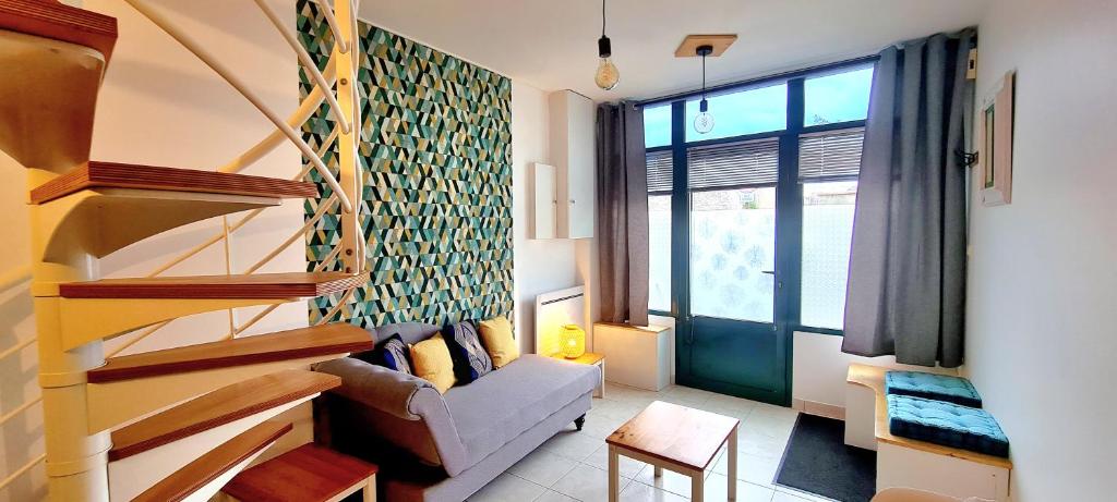 a living room with a couch and a large window at Appartement Samuel centre ville Les Herbiers, 10 min du Puy du Fou in Les Herbiers