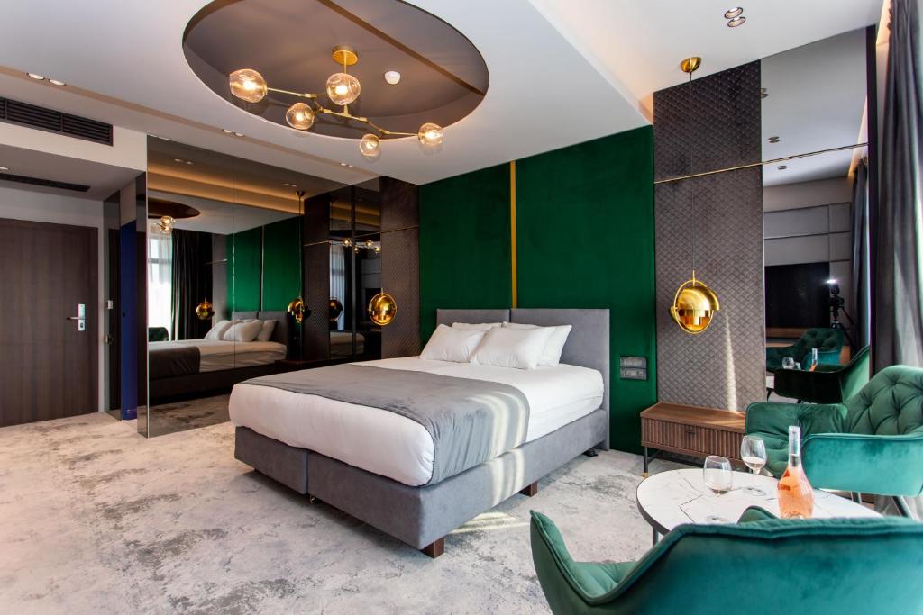 - une chambre avec un lit et un mur vert dans l'établissement Vila Avy, à Haţeg