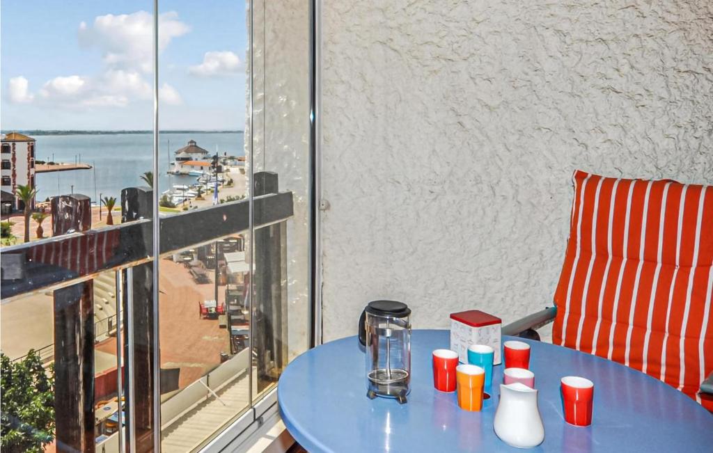 une table bleue avec des tasses au-dessus d'un balcon dans l'établissement 2 Bedroom Cozy Apartment In Le Barcarès, au Barcarès