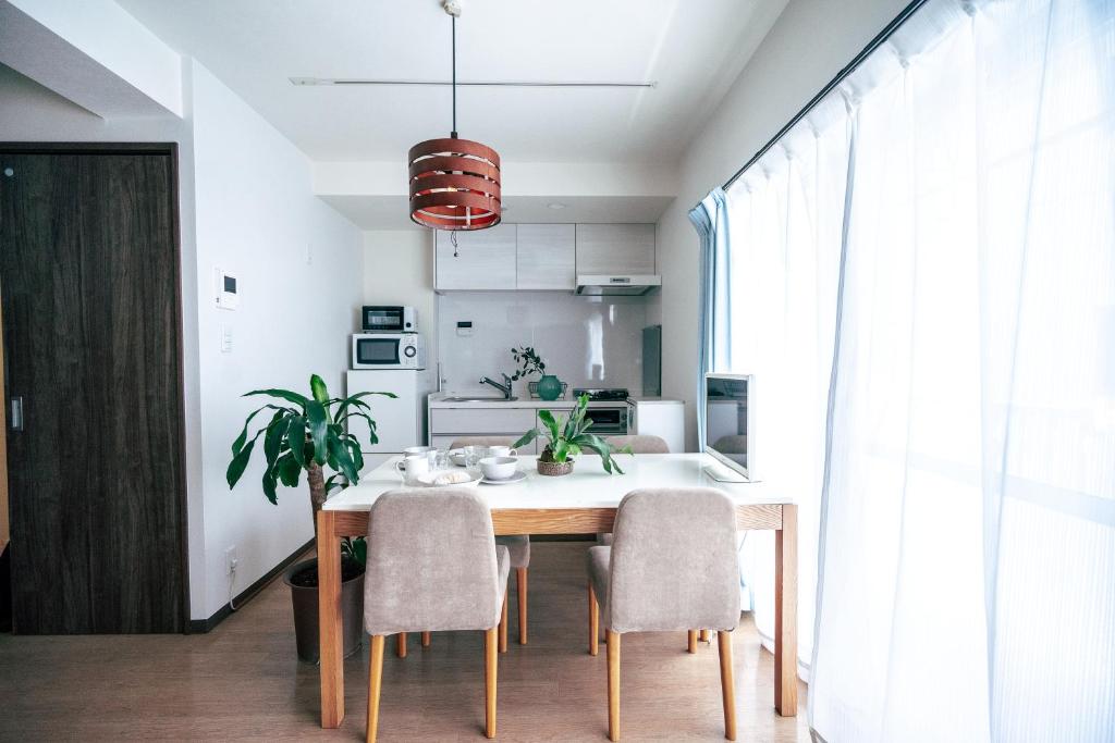 cocina y comedor con mesa y sillas en Home n Lounge en Tokio