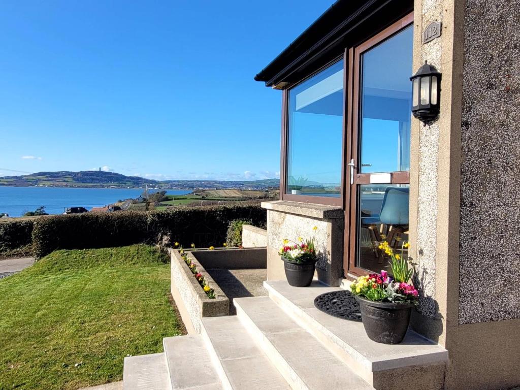 une maison avec deux fleurs en pot sur les escaliers dans l'établissement Loughinvar, Newtownards, à Newtownards