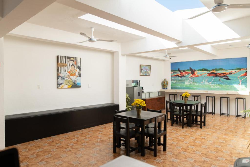 a living room with two tables and a kitchen at Hotel La Catedral Mérida in Mérida