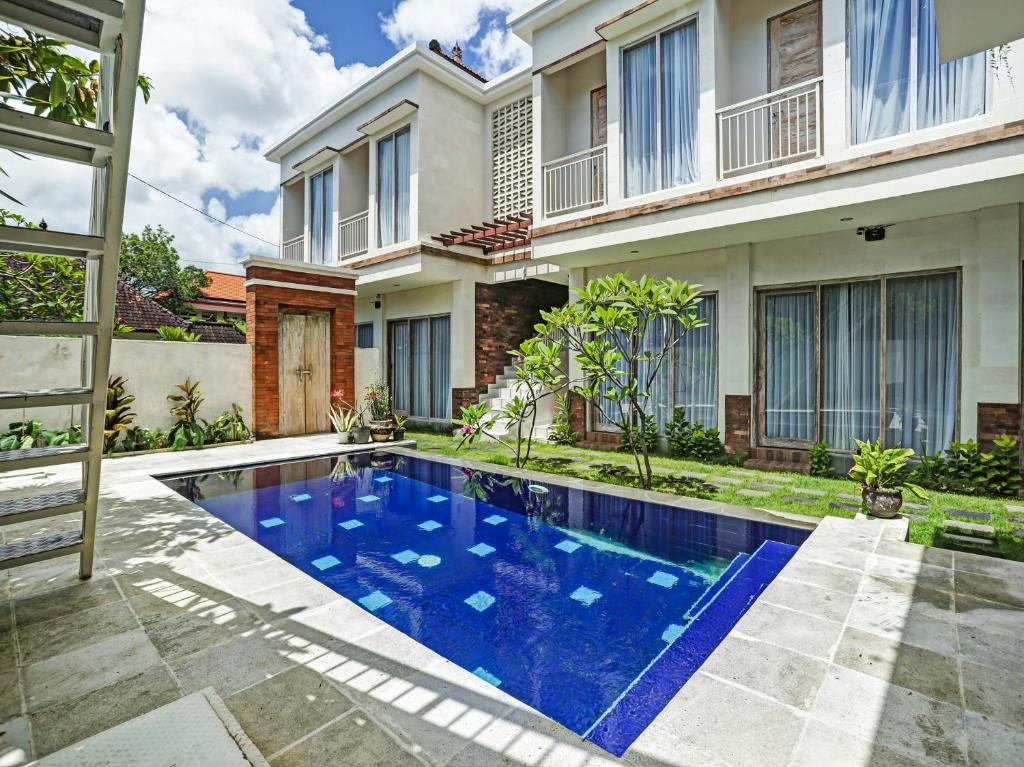 a swimming pool in front of a house at OYO Flagship 90837 Maharani Residence in Seminyak
