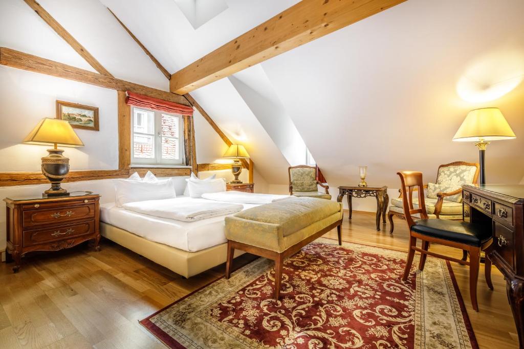 a bedroom with a bed and a table and chairs at Bohemian Hotel in Regensburg
