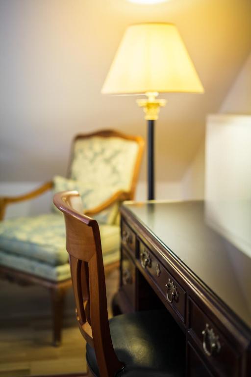 a room with a desk with a lamp and a chair at Bohemian Hotel in Regensburg