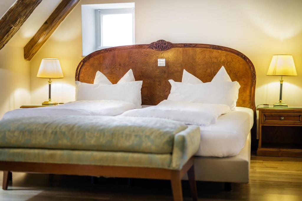 a bedroom with two beds with a wooden headboard at Bohemian Hotel in Regensburg