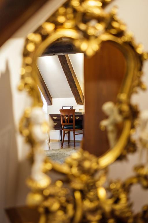 a mirror reflecting a room with a table and a chair at Bohemian Hotel in Regensburg