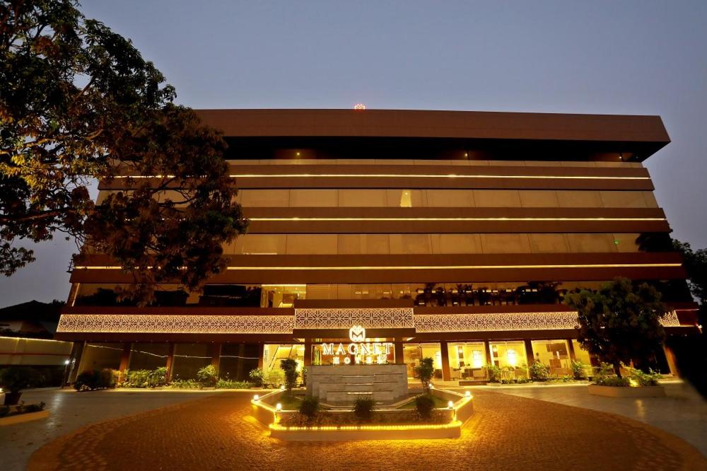 un grande edificio con luci di fronte di Magnet Hotel a Kannur