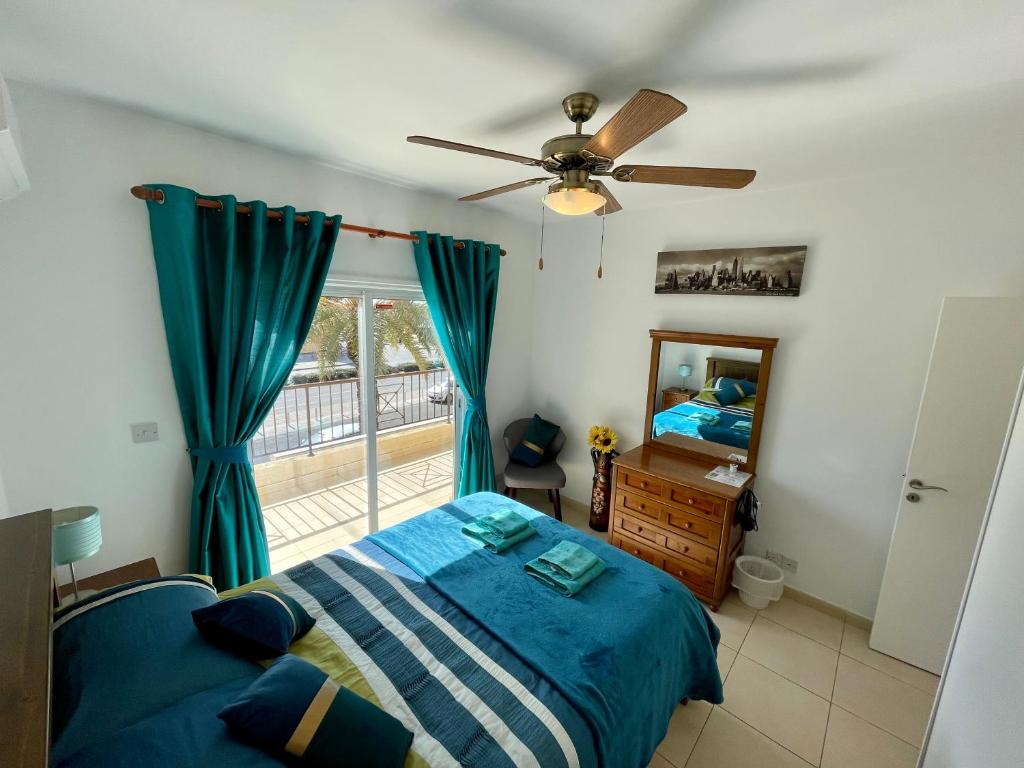 una camera con letto e ventilatore a soffitto di 109 Queens Gardens, Paphos a Paphos