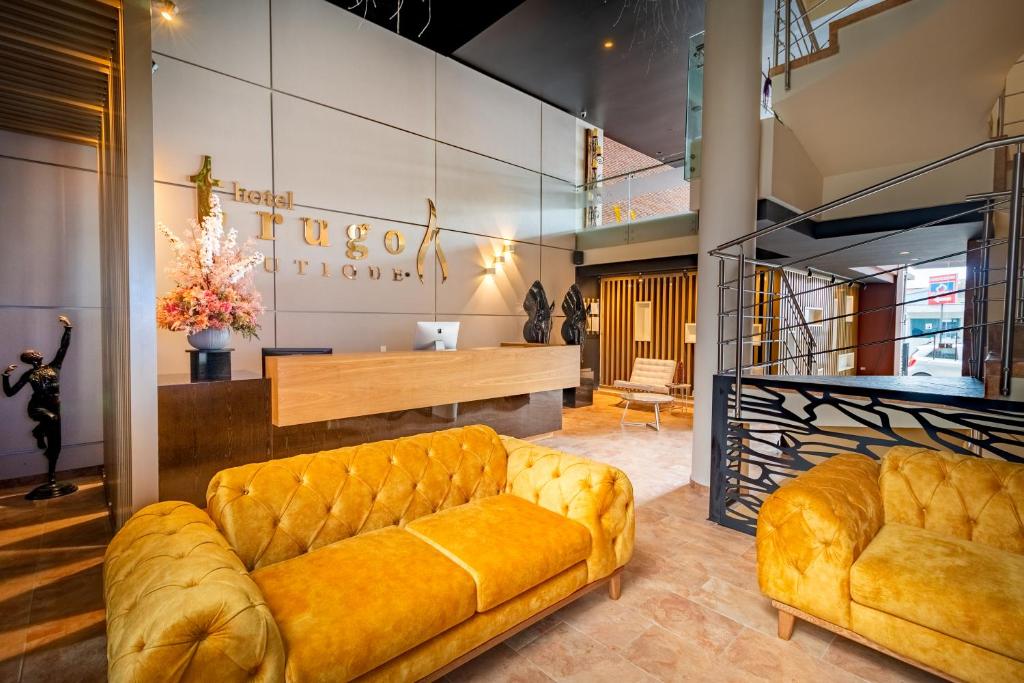 a lobby with a yellow couch and a table at Hotel Trugo Boutique Armenia in Armenia
