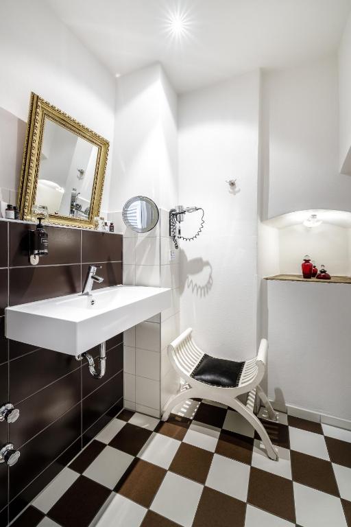 a bathroom with a sink and a chair at Bohemian Hotel in Regensburg