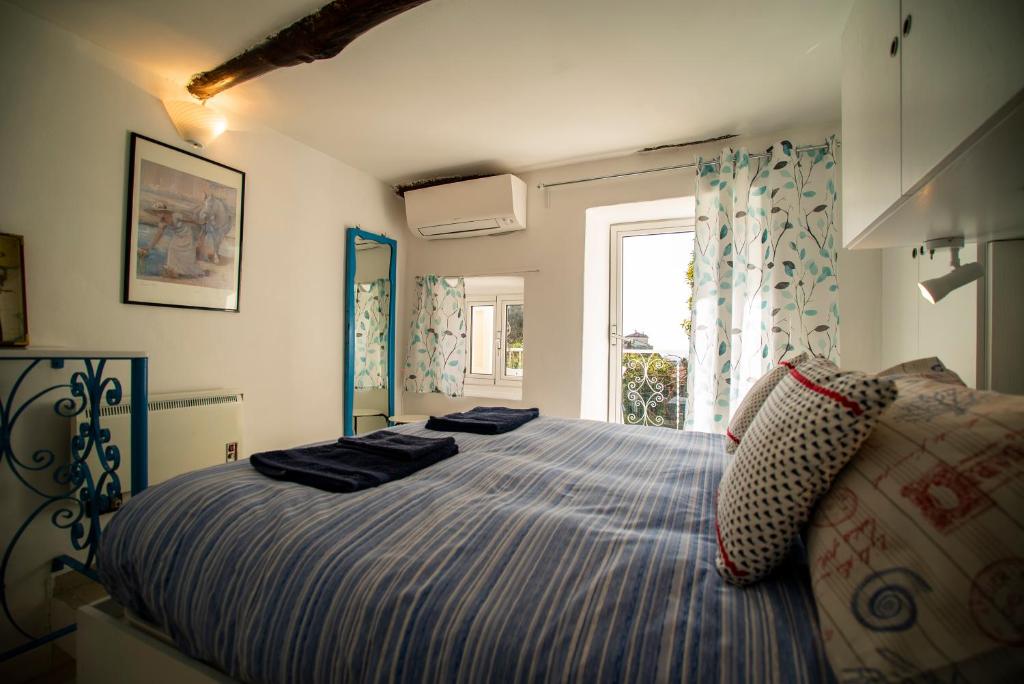 a bedroom with a large bed and a window at Borgo Antico - Il nido di briciola in Lerici