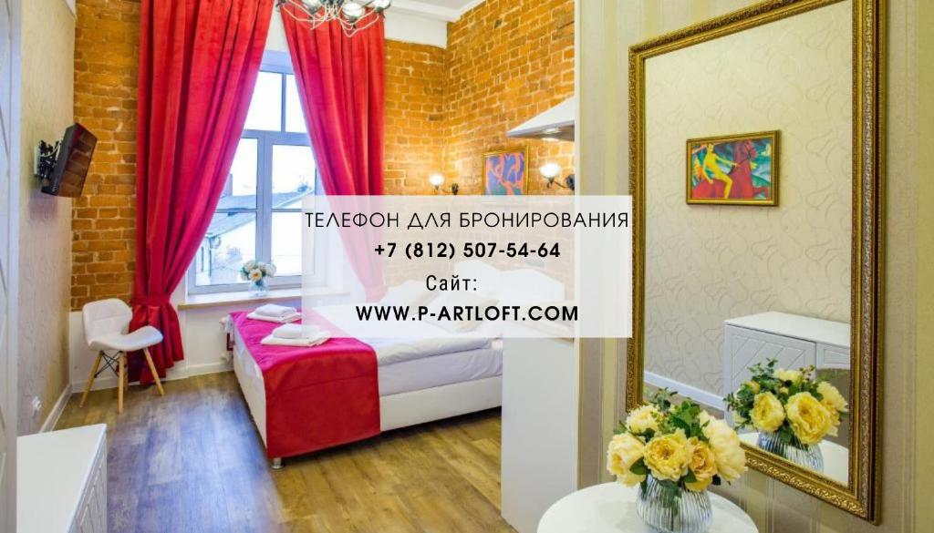 una camera d'albergo con letto e specchio di Petrovskiy Art Loft a San Pietroburgo