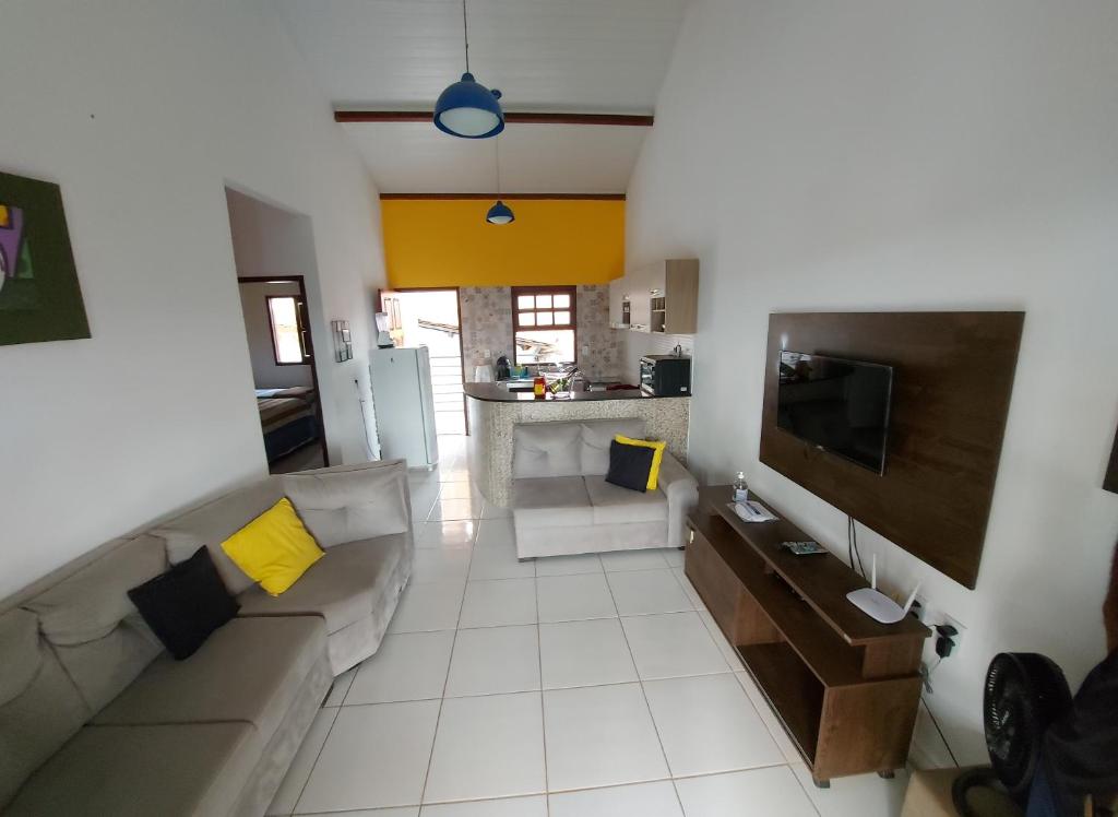 a living room with a couch and a tv at Casas Bela da Chapada in Lençóis