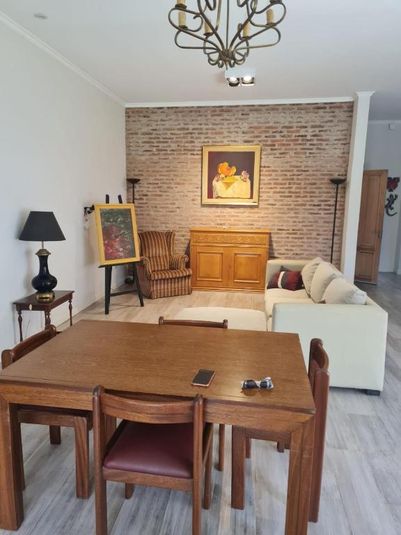 a living room with a table and a couch at Lechuza del Campanario in San Antonio de Areco