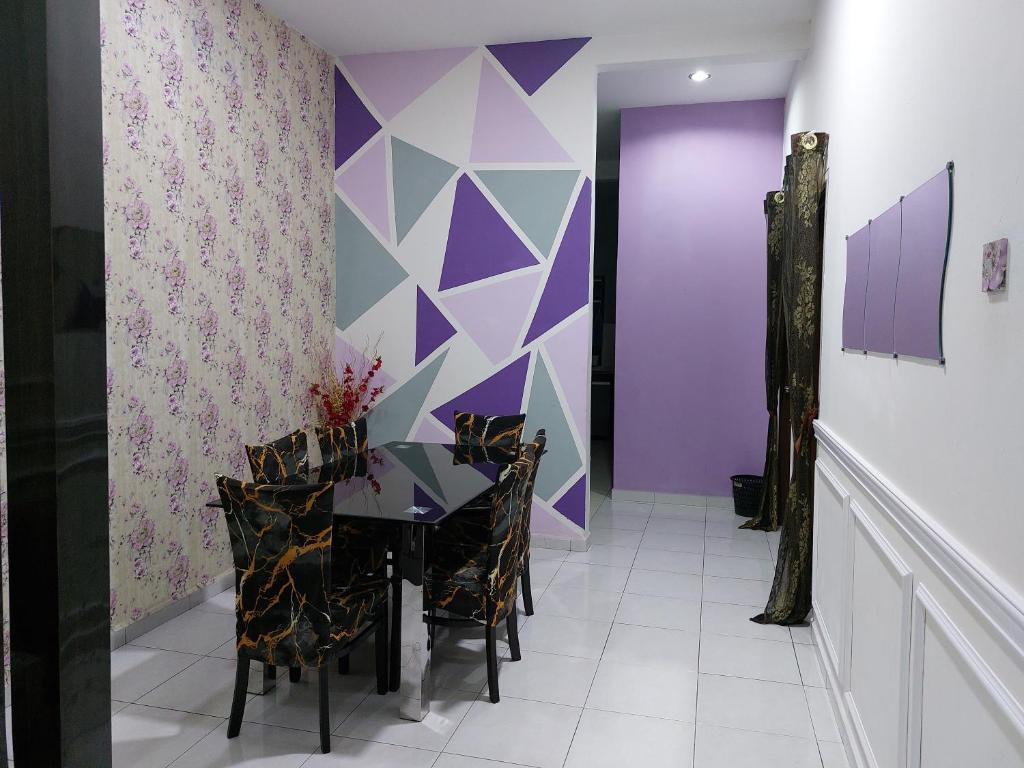 a dining room with a table and chairs and purple walls at Pelangi homestay in Kampung Bota Kiri