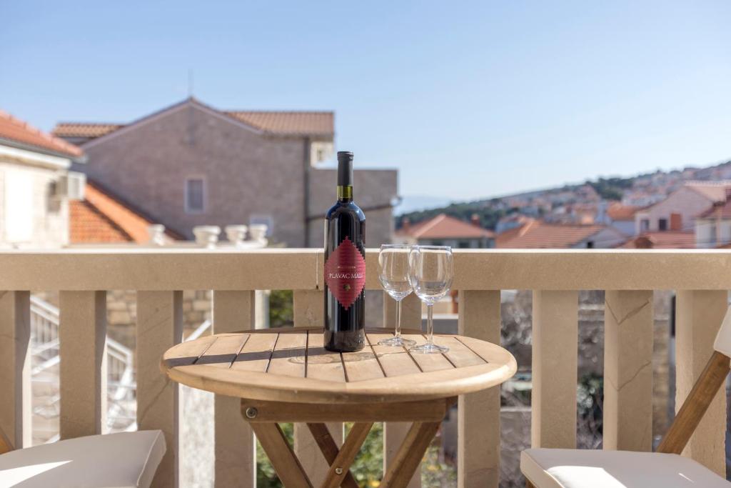 una bottiglia di vino seduta su un tavolo con due bicchieri di Apartment Anna - 20 m from the sea a Postira (Postire)