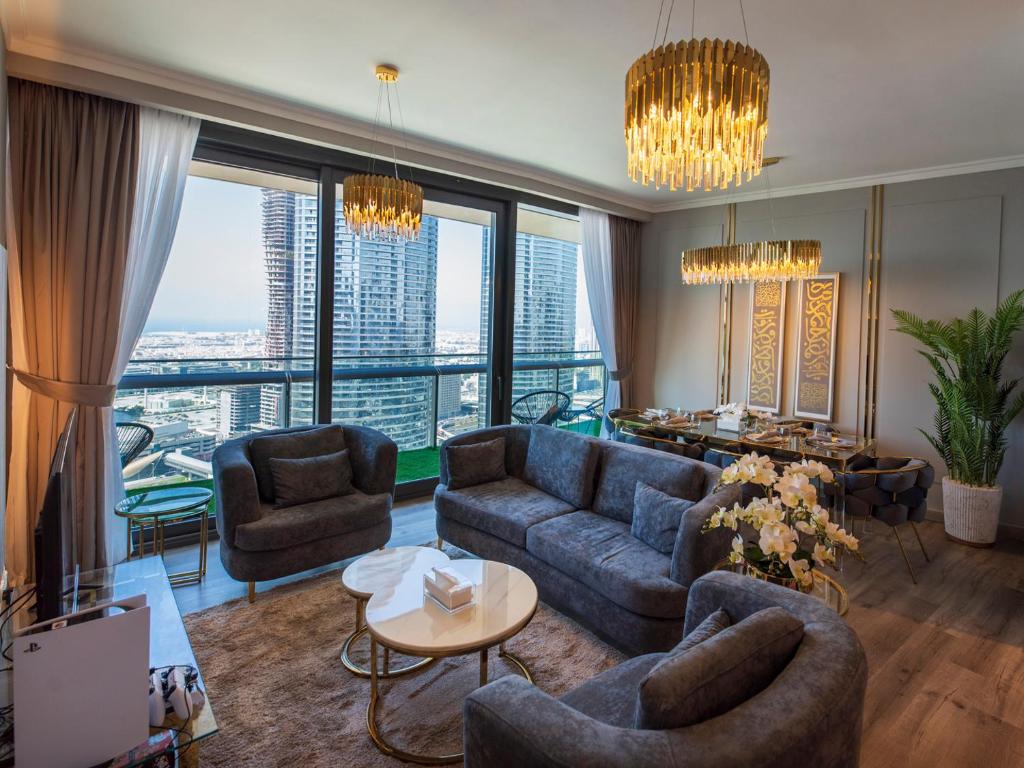 - un salon avec un canapé et des chaises dans un bâtiment dans l'établissement FIRST CLASS 2BR with full DUBAI SKYLINE & SEA view, à Dubaï