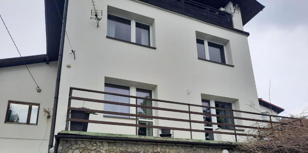 a white building with windows and a balcony at Alfa2 apartament 1 in Bystra