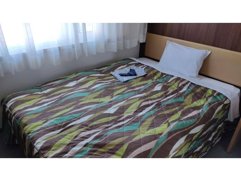 een bed met een kleurrijk dekbed in een kamer bij Central Hotel Toride - Vacation STAY 09913v in Toride