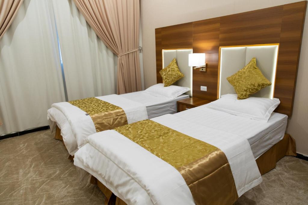 ein Hotelzimmer mit 2 Betten und einem Fenster in der Unterkunft الليل لك للشقق الفندقيه in Ha'il