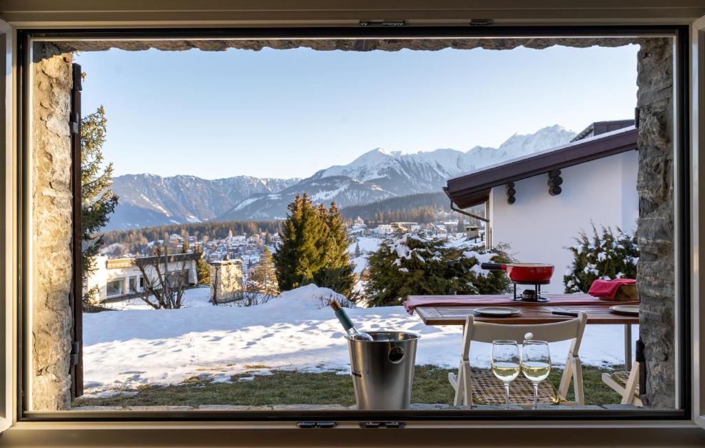 a window with a view of a snowy mountain at Charmantes Apartment mit grossem Garten .Kids4free. in Flims