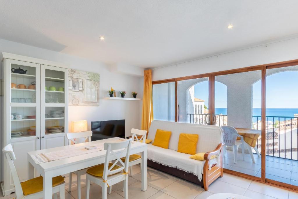 a living room with a couch and a table with chairs at Altea Top Quality Duplex-home in Altea