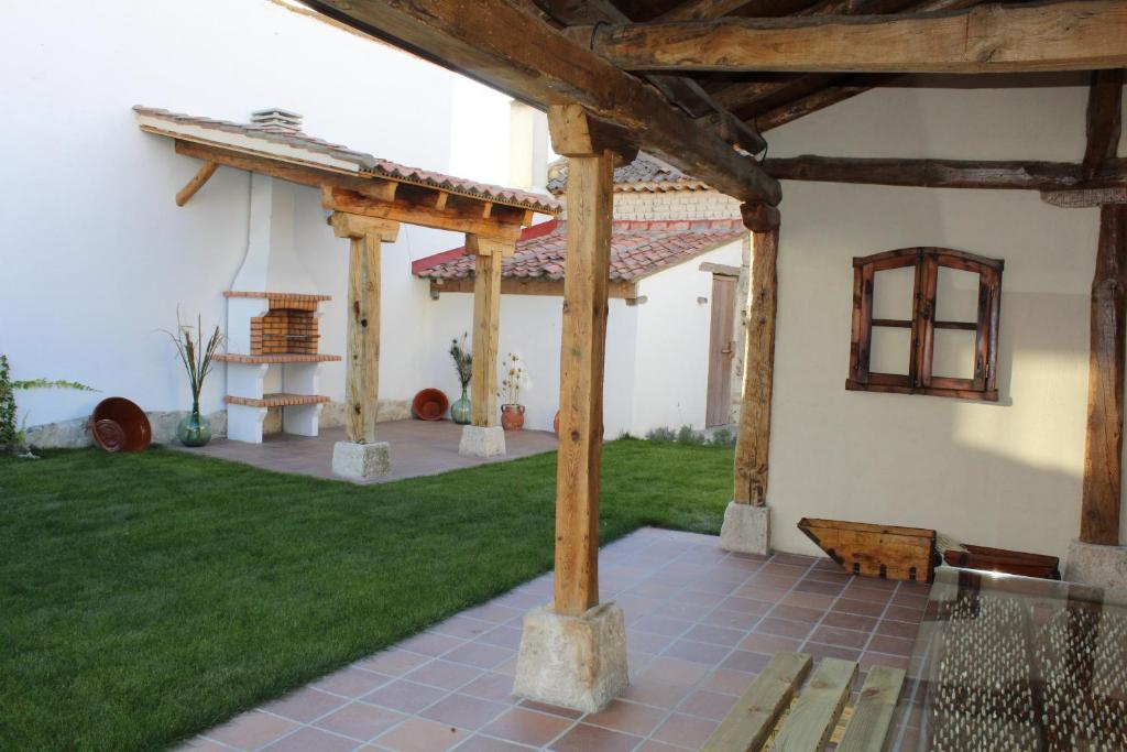 un patio con pergolato in legno e prato verde di CASA TEO a Chañe