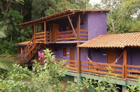 a purple house with a porch on the side of it at Pousada O Canto das Sereias in Trindade