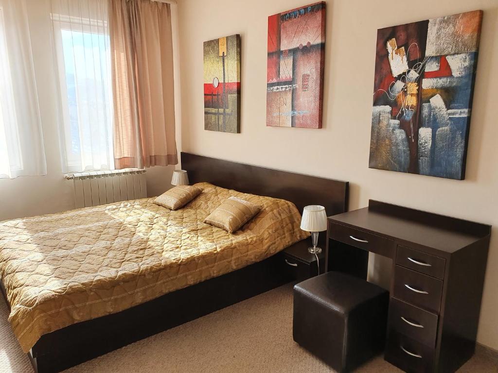 1 dormitorio con cama y escritorio. en Spacious and Cosy Apartment in Bansko Royal Towers Complex, en Bansko