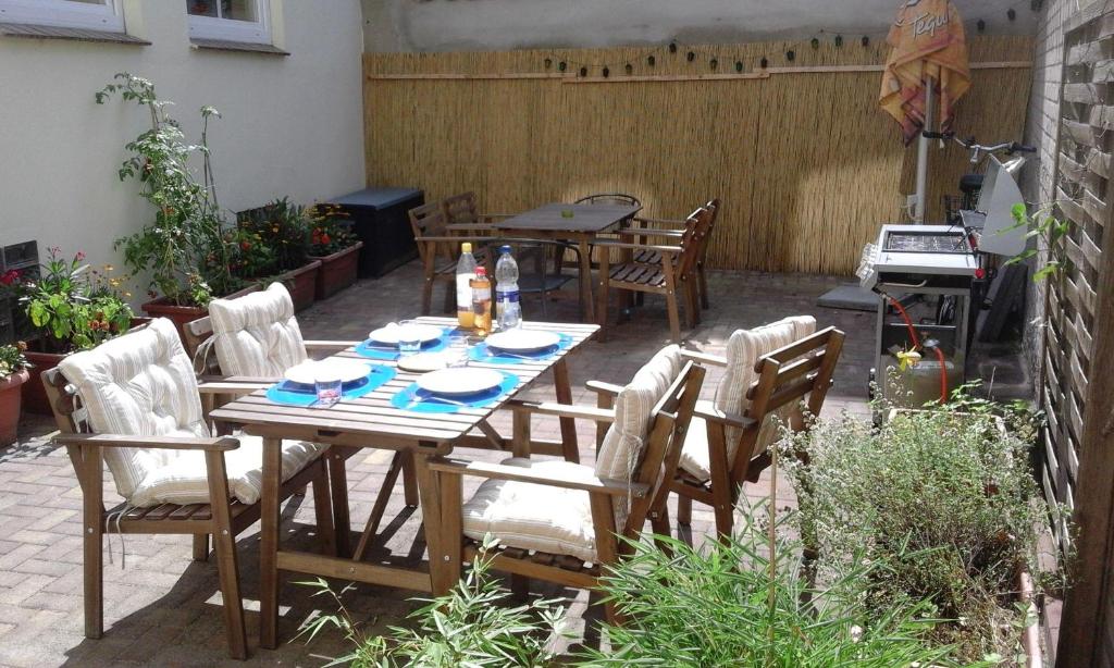 eine Terrasse mit einem Tisch, Stühlen und einem Grill in der Unterkunft 1-Zimmer-Apartment 1 im 1. Obergeschoss in Lübeck