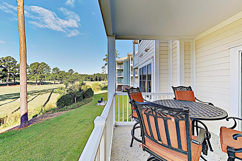 a balcony with a table and chairs on a house at Magnolia Point Apt 204 in Myrtle Beach
