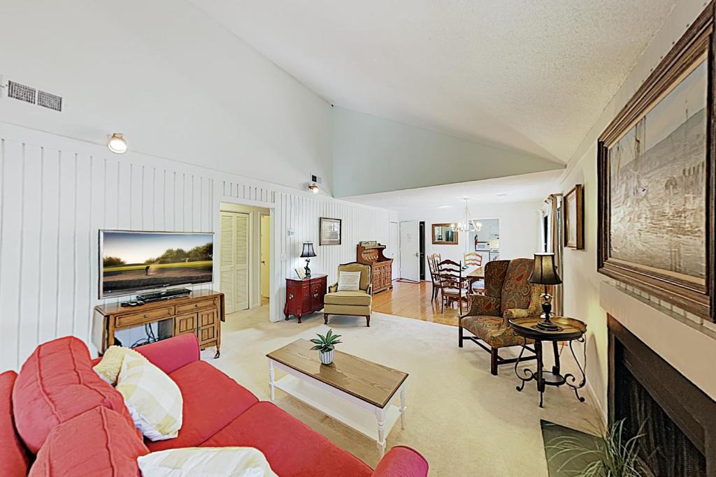 sala de estar con sofá rojo y mesa en 442 Oceanwoods en Kiawah Island