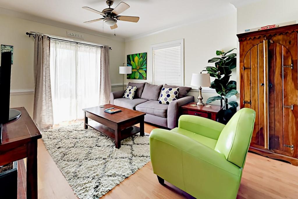 a living room with a couch and a green chair at Silver Shores in Tybee Island