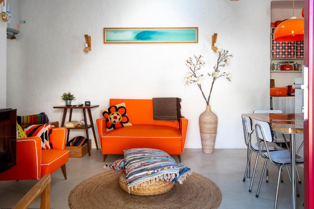 a living room with an orange chair and a table at Hillside 1 Aljezur old town in Aljezur