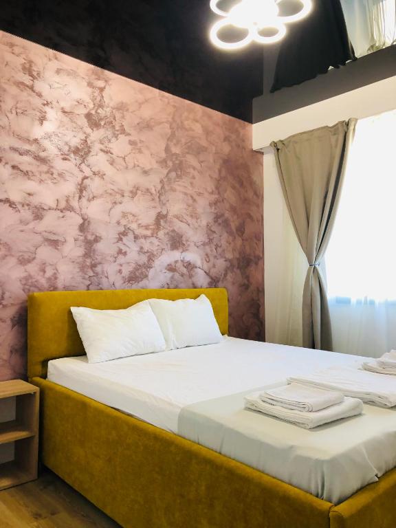 a bedroom with two beds and a pink wall at Happy Apartments Mamaia Nord 2 Camere in Mamaia Sat/Năvodari