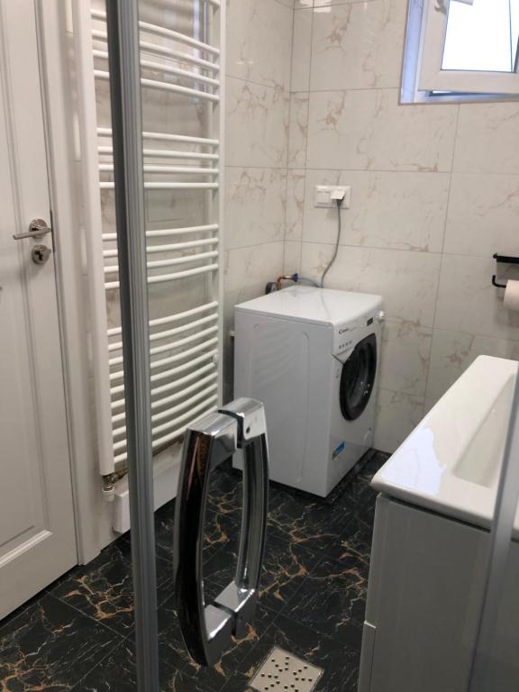 La salle de bains est pourvue d'un lave-linge et d'un sèche-linge. dans l'établissement Brand New Downtown Studio, à Bucarest