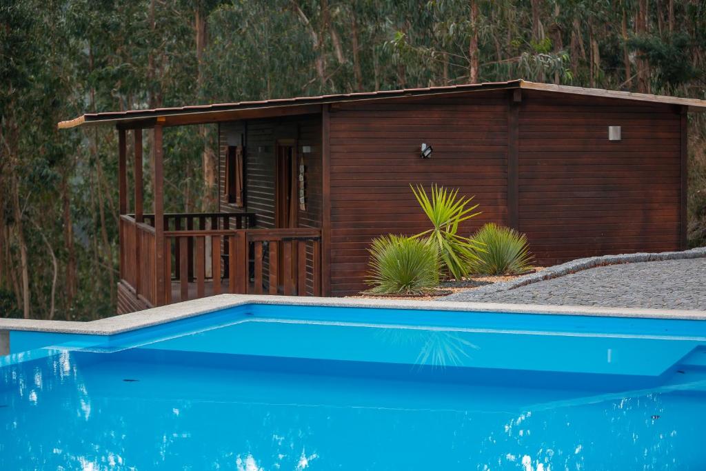 a small cabin with a pool in front of it at Recanto do Escalheiro in Vieira do Minho