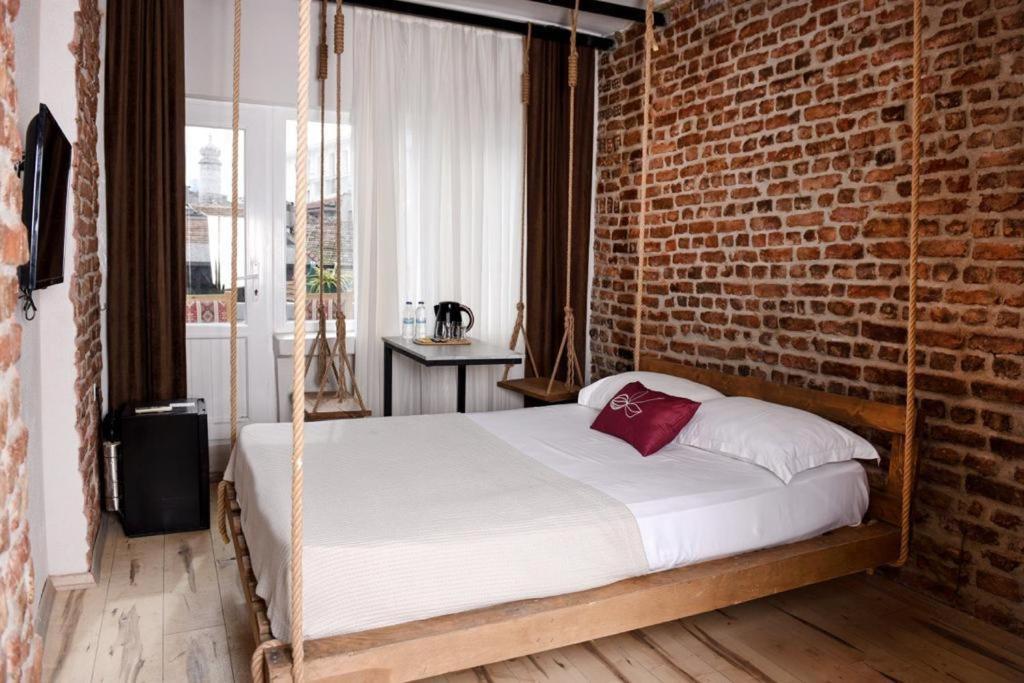 a bedroom with a swinging bed with a brick wall at AYSA Hotel in Istanbul