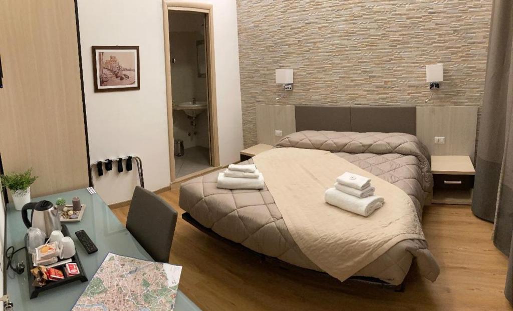una camera da letto con un letto e asciugamani di Castel Sant'Angelo Inn a Roma