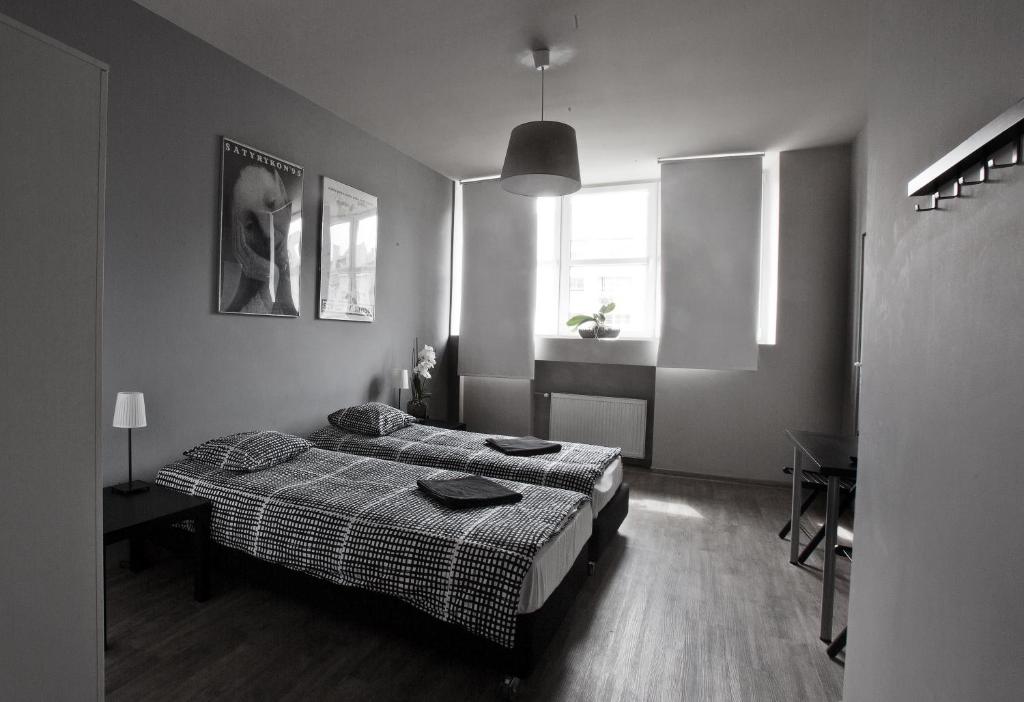a black and white bedroom with a bed and a window at Corner Hostel in Wrocław